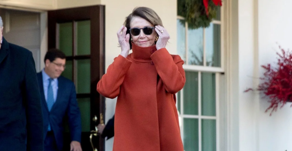 Nancy Pelosi red coat and sunglasses