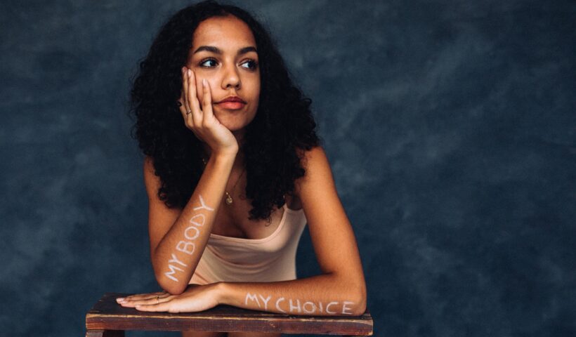 girl with my body my choice written on her arms to protest roe v. wade and abortion rights being overturned