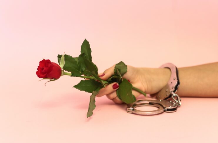 cuffing season, handcuff holding rose